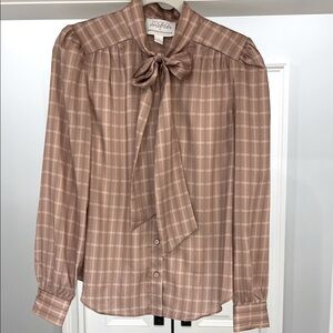 Long sleeve plaid blouse with adorable bow tie detail.